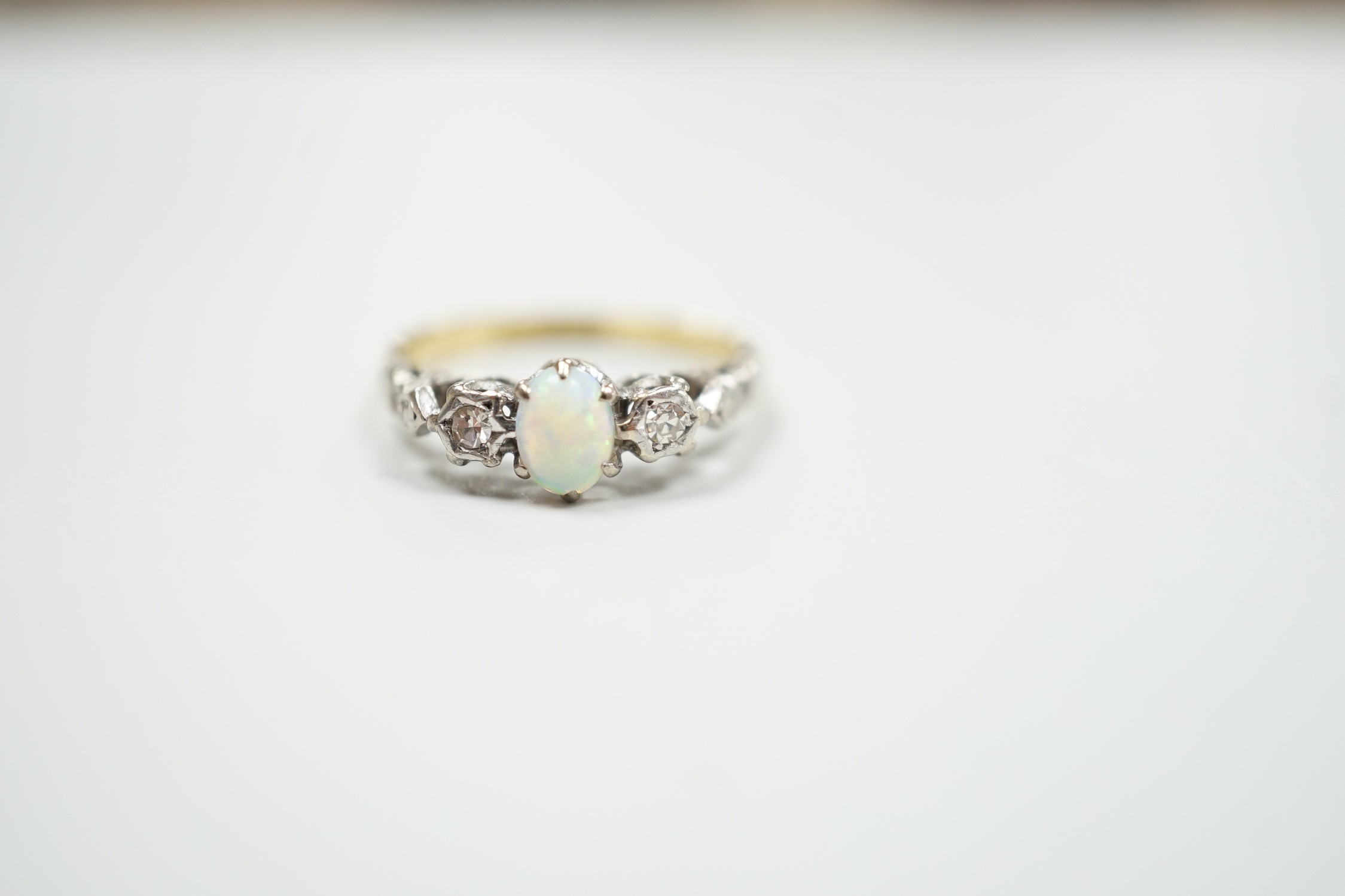 An 18ct and plat, single stone cabochon white opal and two stone diamond set ring, size L/M, gross weight 2.8 grams.